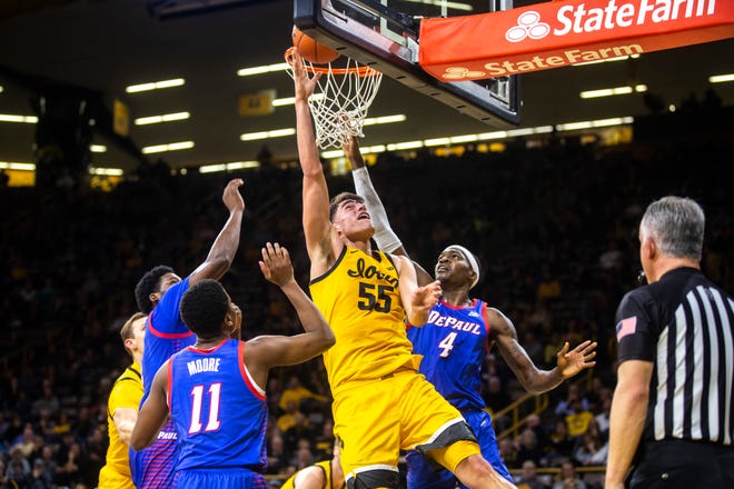 Iowa center Luka Garza (55) makes a basket as DePaul's Romeo Weems, Charlie Moore (11), and Paul Reed (4) defend during a NCAA non-conference men's basketball game, Monday, Nov., 11, 2019, at Carver-Hawkeye Arena in Iowa City, Iowa.