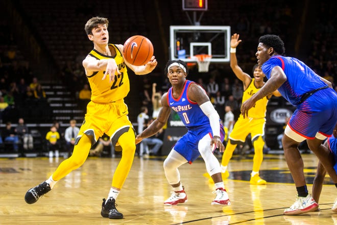 Iowa forward Patrick McCaffery (22) passes to a teammate as DePaul's Markese Jacobs (0) and Romeo Weems, right, defend during a NCAA non-conference men's basketball game, Monday, Nov., 11, 2019, at Carver-Hawkeye Arena in Iowa City, Iowa.