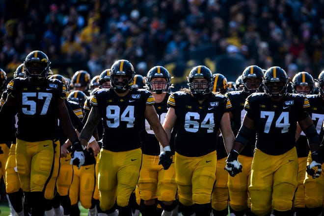 Iowa players, from left, Chauncey Golston, A.J. Epenesa, Kyler Schott, and Tristan Wirfs run out onto the field with teammates before a NCAA Big Ten Conference football game, Saturday, Nov. 23, 2019, at Kinnick Stadium in Iowa City, Iowa.