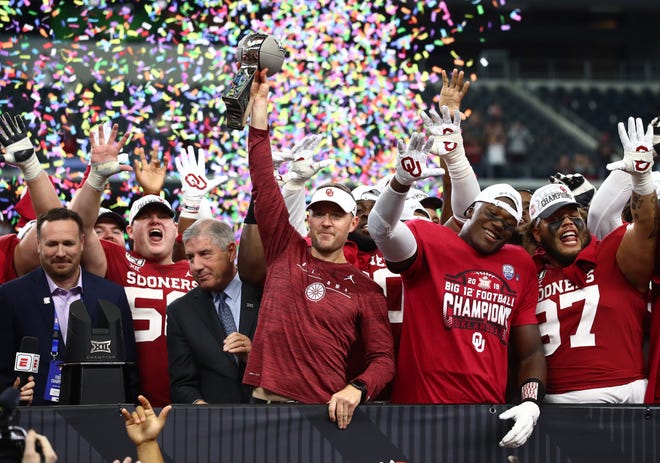 Oklahoma Sooner head coach Lincoln Riley hoist the Big 12 Conference championship trophy after a victory over the Baylor Bears.