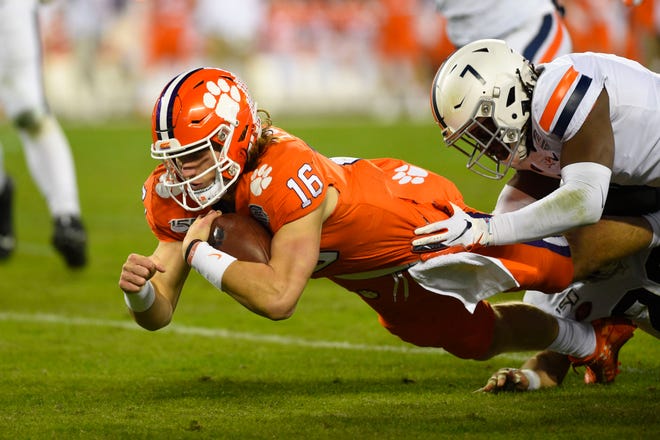 Clemson Tigers quarterback Trevor Lawrence is tackled by Virginia Cavaliers safety Chris Moore in second quarter of the ACC championship game.