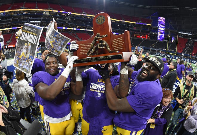 The LSU Tigers hoist the SEC championship trophy after their 37-10 victory over the Georgia Bulldogs.