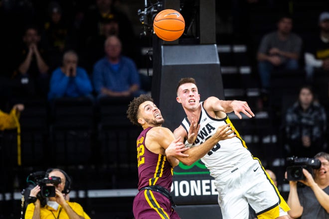 Iowa guard Joe Wieskamp, right, gets tangled up with Minnesota's Gabe Kalscheur (22) during a NCAA Big Ten Conference men's basketball game, Monday, Dec. 9, 2019, at Carver-Hawkeye Arena in Iowa City, Iowa.