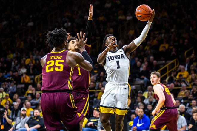 Iowa guard Joe Toussaint (1) drives to the basket against Minnesota's Tre' Williams (1) and Daniel Oturu (25) during a NCAA Big Ten Conference men's basketball game, Monday, Dec. 9, 2019, at Carver-Hawkeye Arena in Iowa City, Iowa.
