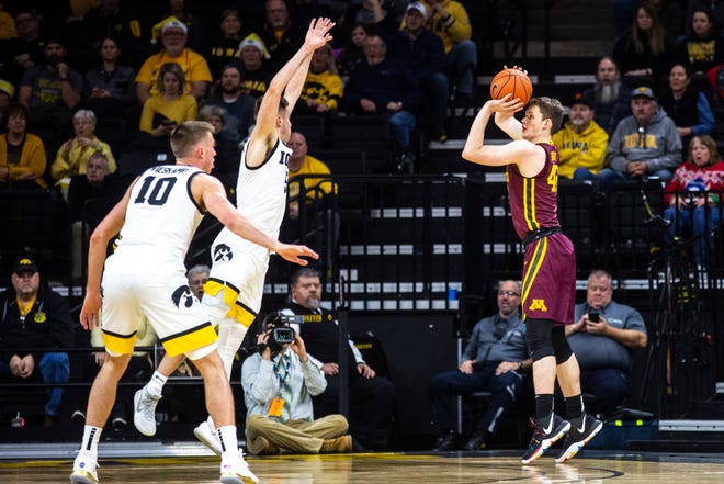 Minnesota's Michael Hurt, right, makes a 3-point basket as Iowa guard CJ Fredrick defends during a NCAA Big Ten Conference men's basketball game, Monday, Dec. 9, 2019, at Carver-Hawkeye Arena in Iowa City, Iowa.