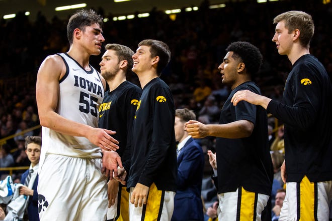 Iowa center Luka Garza (55) gets greeted by teammates Austin Ash, Nicolas Hobbs, and Michael Baer during a NCAA Big Ten Conference men's basketball game, Monday, Dec. 9, 2019, at Carver-Hawkeye Arena in Iowa City, Iowa.