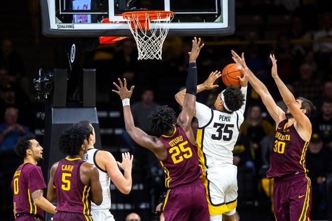 Iowa forward Cordell Pemsl (35) tries to put up a shot as Minnesota's Daniel Oturu (25) and Alihan Demir, right, defend during a NCAA Big Ten Conference men's basketball game, Monday, Dec. 9, 2019, at Carver-Hawkeye Arena in Iowa City, Iowa.