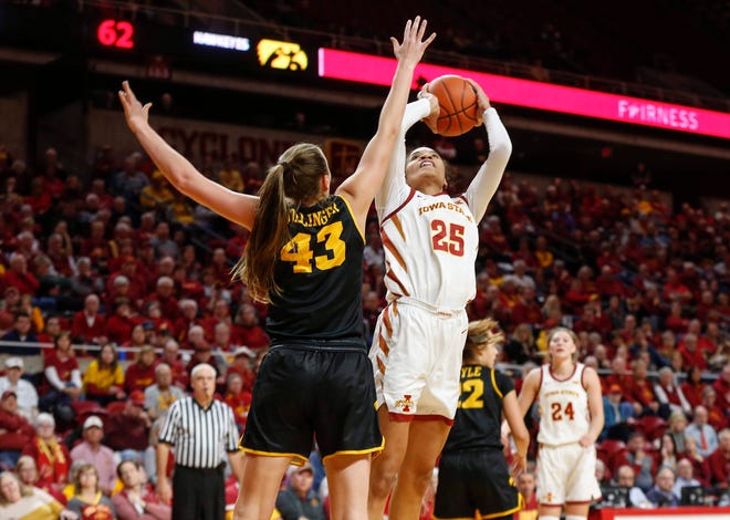 Iowa State junior Kristen Scott puts up a shot over the reach of Iowa senior Amanda Ollinger in the fourth quarter during the CyHawk Series women's basketball game on Wednesday, Dec. 11, 2019, at Hilton Coliseum in Ames, Iowa.