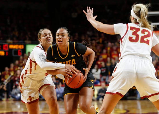 Iowa junior Alexis Sevillian maintains control of the ball as Iowa State junior Rae Johnson attempts to knock it away in the first quarter during the CyHawk Series women's basketball game on Wednesday, Dec. 11, 2019, at Hilton Coliseum in Ames, Iowa.