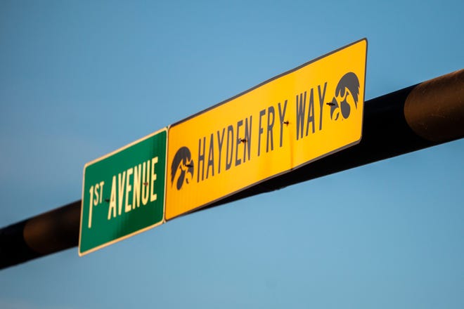 A sign for First Avenue/Hayden Fry Way with images of the Tiger Hawk logo is pictured as the sun rises, Wednesday, Dec. 18, 2019, along First Avenue/Hayden Fry Way near the Iowa City/Coralville Area Convention & Visitors Bureau in Coralville, Iowa. Fry died Dec. 17, he was 90 years old.