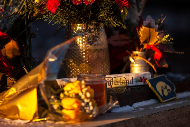 Flowers and a pair of yellow sunglasses rest at the feet of a statue of former Iowa Hawkeyes football head coach Hayden Fry is pictured as the sun rises, Wednesday, Dec. 18, 2019, along First Avenue/Hayden Fry Way near the Iowa City/Coralville Area Convention & Visitors Bureau in Coralville, Iowa. Fry died Dec. 17, he was 90 years old.