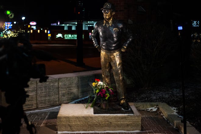 Flowers rest at the feet of a statue of former Iowa Hawkeyes football head coach Hayden Fry, Tuesday, Dec. 17, 2019, along 1st Avenue/Hayden Fry Way in Coralville, Iowa. Fry died Dec. 17, he was 90 years old.