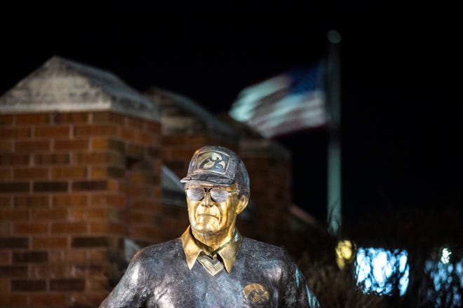 An American flag waves in the background behind a statue of former Iowa Hawkeyes football head coach Hayden Fry, Tuesday, Dec. 17, 2019, along 1st Avenue/Hayden Fry Way in Coralville, Iowa. Fry died Dec. 17, he was 90 years old.