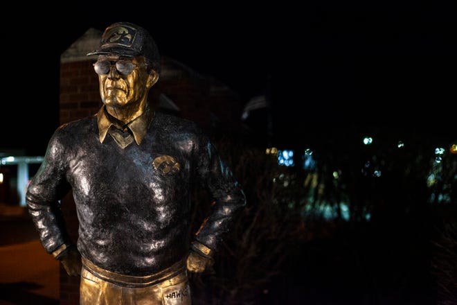 Flowers rest at the feet of a statue of former Iowa Hawkeyes football head coach Hayden Fry, Tuesday, Dec. 17, 2019, along 1st Avenue/Hayden Fry Way in Coralville, Iowa. Fry died Dec. 17, he was 90 years old.