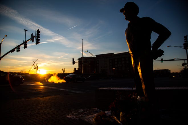 A statue of former Iowa Hawkeyes football head coach Hayden Fry is pictured as the sun rises, Wednesday, Dec. 18, 2019, along First Avenue/Hayden Fry Way near the Iowa City/Coralville Area Convention & Visitors Bureau in Coralville, Iowa. Fry died Dec. 17, he was 90 years old.