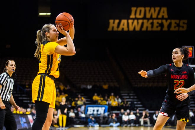 Iowa guard Kathleen Doyle, left, makes a 3-point basket during a NCAA college Big Ten Conference women's basketball game, Thursday, Jan. 9, 2020, at Carver-Hawkeye Arena in Iowa City, Iowa.