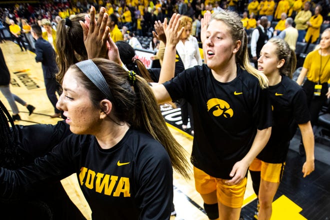 Iowa players, from left, McKenna Warnock, Monika Czinano and Kathleen Doyle high-five teammates before a NCAA college Big Ten Conference women's basketball game against Maryland, Thursday, Jan. 9, 2020, at Carver-Hawkeye Arena in Iowa City, Iowa.