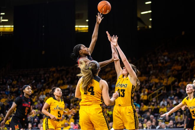 Maryland guard Diamond Miller makes a basket as Iowa's McKenna Warnock (14) and Amanda Ollinger (43) defend during a NCAA college Big Ten Conference women's basketball game, Thursday, Jan. 9, 2020, at Carver-Hawkeye Arena in Iowa City, Iowa.
