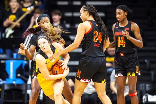 Iowa's McKenna Warnock (14) battles for a jump ball against Maryland guard Kaila Charles, left, Stephanie Jones (24) and Diamond Miller (14) during a NCAA college Big Ten Conference women's basketball game, Thursday, Jan. 9, 2020, at Carver-Hawkeye Arena in Iowa City, Iowa.