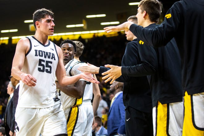 Iowa center Luka Garza (55) gets high-fives from teammates while heading to the bench during a NCAA college Big Ten Conference men's basketball game, Friday, Jan. 10, 2020, at Carver-Hawkeye Arena in Iowa City, Iowa.