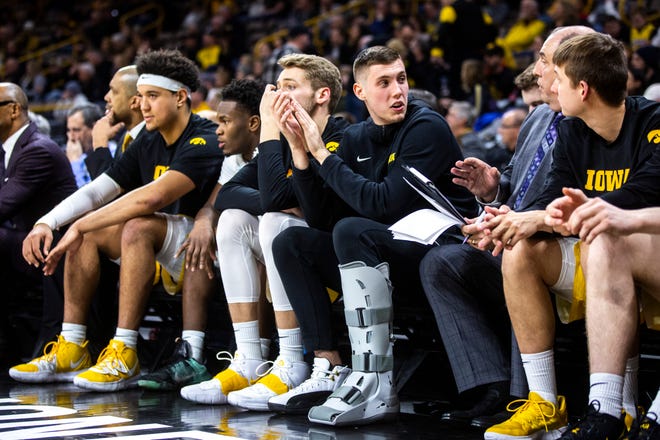 Iowa guard CJ Fredrick, third from right, talks with director of operations Al Seibert during a NCAA college Big Ten Conference men's basketball game, Friday, Jan. 10, 2020, at Carver-Hawkeye Arena in Iowa City, Iowa.