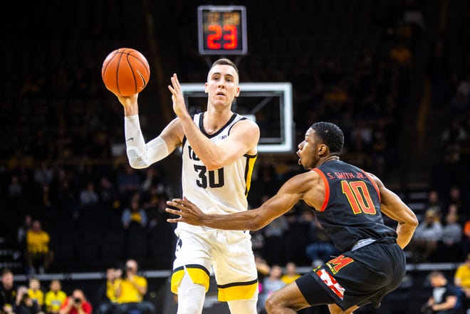 Iowa guard Connor McCaffery (30) looks to pass as Maryland's Serrel Smith Jr. (10) defends during a NCAA college Big Ten Conference men's basketball game, Friday, Jan. 10, 2020, at Carver-Hawkeye Arena in Iowa City, Iowa.