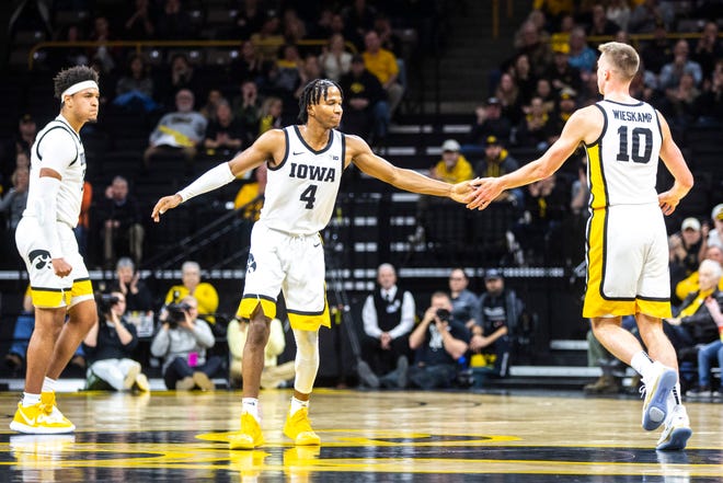 Iowa guard Joe Wieskamp (10) gets a high-five from teammate Bakari Evelyn (4) while settling in on defense after making a 3-point basket as Cordell Pemsl, far left, reacts during a NCAA college Big Ten Conference men's basketball game, Friday, Jan. 10, 2020, at Carver-Hawkeye Arena in Iowa City, Iowa.