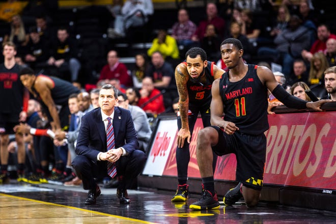 Maryland head coach Mark Turgeon crouches down along the baseline while players Eric Ayala (5) and Darryl Morsell (11) wait to check in during a NCAA college Big Ten Conference men's basketball game, Friday, Jan. 10, 2020, at Carver-Hawkeye Arena in Iowa City, Iowa.