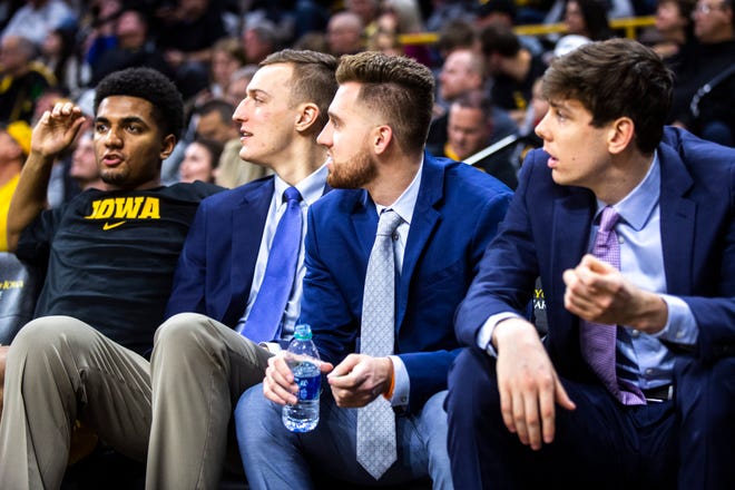 Iowa players, from left, Nicolas Hobbs, Jack Nunge, Jordan Bohannon, and Patrick McCaffery sit on the bench during a NCAA college Big Ten Conference men's basketball game, Friday, Jan. 10, 2020, at Carver-Hawkeye Arena in Iowa City, Iowa.