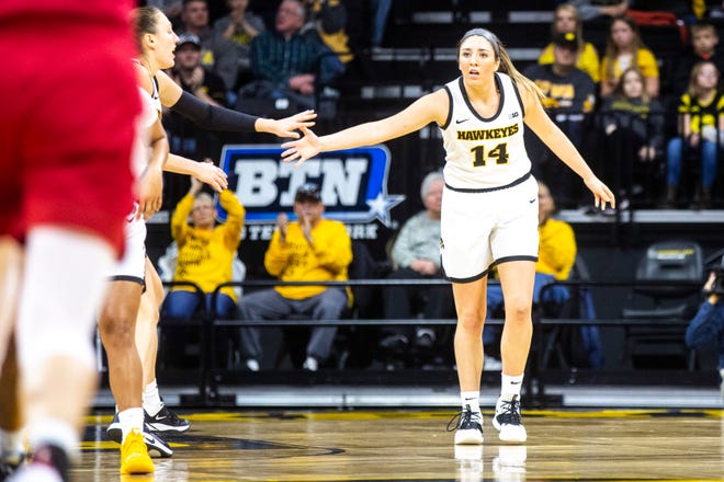 Iowa's McKenna Warnock (14) gets a high-five from teammate Amanda Ollinger, left, during a NCAA Big Ten Conference women's basketball game, Sunday, Jan. 12, 2020, at Carver-Hawkeye Arena in Iowa City, Iowa.