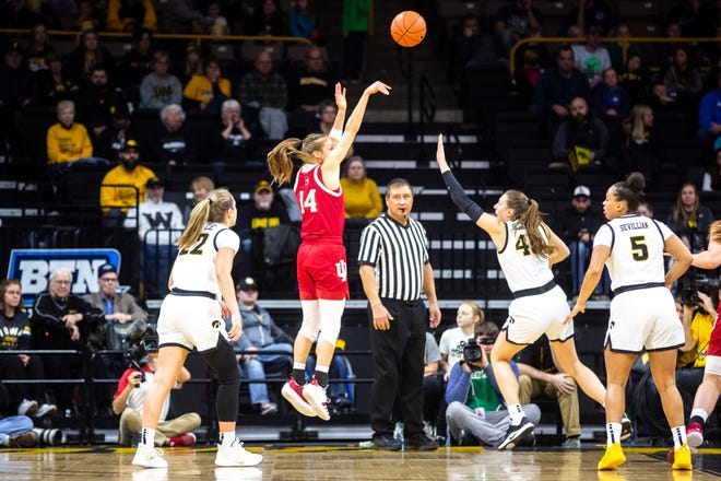 Indiana guard Ali Patberg (14) makes a 2-point basket as Iowa forward Amanda Ollinger (43) and Iowa guard Kathleen Doyle (22) defend during a NCAA Big Ten Conference women's basketball game, Sunday, Jan. 12, 2020, at Carver-Hawkeye Arena in Iowa City, Iowa.
