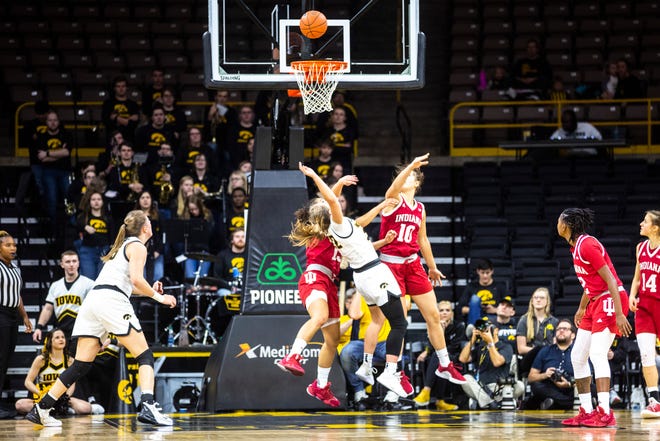 Iowa guard Kathleen Doyle, center, draws a foul while driving to the basket against Indiana's Jaelynn Penn, left, and Aleksa Gulbe (10) during a NCAA Big Ten Conference women's basketball game, Sunday, Jan. 12, 2020, at Carver-Hawkeye Arena in Iowa City, Iowa.