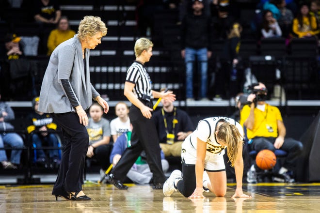 Iowa head coach Lisa Bluder goes to check on Iowa guard Kathleen Doyle (22) heading into a timeout during a NCAA Big Ten Conference women's basketball game, Sunday, Jan. 12, 2020, at Carver-Hawkeye Arena in Iowa City, Iowa.