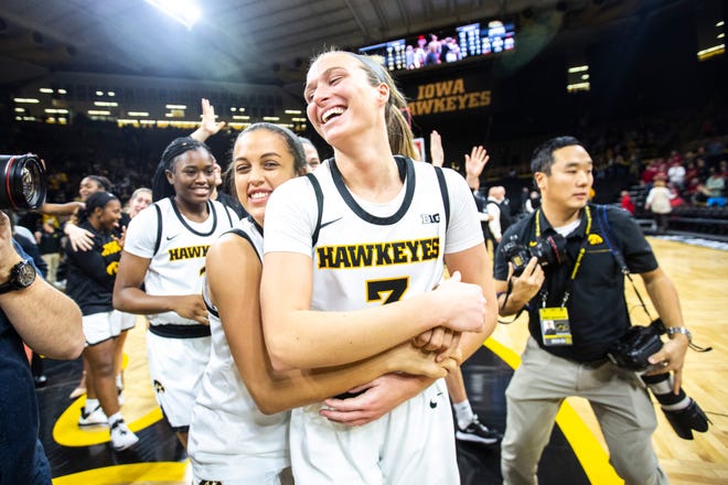 Iowa guard Makenzie Meyer, center, is embraced by teammate Gabbie Marshall as Hawkeyes players celebrate after defeating Indiana during a NCAA Big Ten Conference women's basketball game, Sunday, Jan. 12, 2020, at Carver-Hawkeye Arena in Iowa City, Iowa.