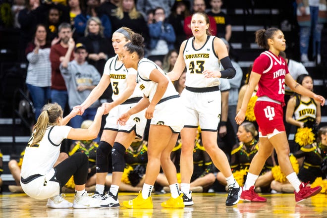 Iowa guard Kathleen Doyle (22) gets a hand from teammates Iowa guard Makenzie Meyer (3) and Iowa guard Alexis Sevillian (5) after taking a fall during a NCAA Big Ten Conference women's basketball game against Indiana, Sunday, Jan. 12, 2020, at Carver-Hawkeye Arena in Iowa City, Iowa.