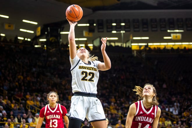 Iowa guard Kathleen Doyle (22) makes a basket as Indiana guards Ali Patberg (14) and Jaelynn Penn (13) defend during a NCAA Big Ten Conference women's basketball game, Sunday, Jan. 12, 2020, at Carver-Hawkeye Arena in Iowa City, Iowa.
