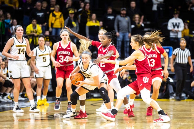 Indiana's Keyanna Warthen (2) and Ali Patberg, right, defend Iowa guard Makenzie Meyer (3) during a NCAA Big Ten Conference women's basketball game, Sunday, Jan. 12, 2020, at Carver-Hawkeye Arena in Iowa City, Iowa.