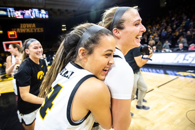 Iowa guard Makenzie Meyer (3) is embraced by teammate Gabbie Marshall (24) as Hawkeyes players celebrate after defeating Indiana during a NCAA Big Ten Conference women's basketball game, Sunday, Jan. 12, 2020, at Carver-Hawkeye Arena in Iowa City, Iowa.