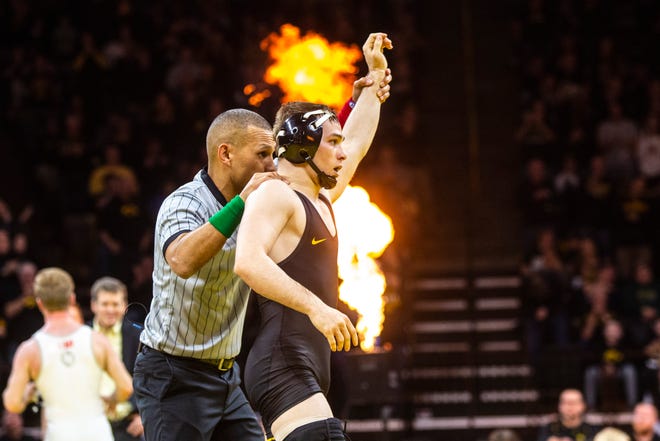 Iowa's Spencer Lee has his hand raised after a match against Ohio State at 125 pounds during a NCAA Big Ten Conference wrestling dual, Friday, Jan. 24, 2020, at Carver-Hawkeye Arena in Iowa City, Iowa.