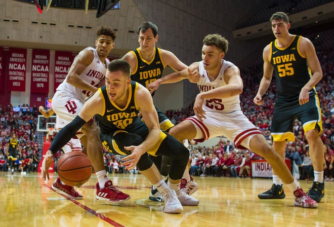 Iowa guard Connor McCaffery (30) falls on the ball during the second half of an NCAA college basketball game against Indiana, Thursday, Feb. 13, 2020, in Bloomington, Ind. (AP Photo/Doug McSchooler)