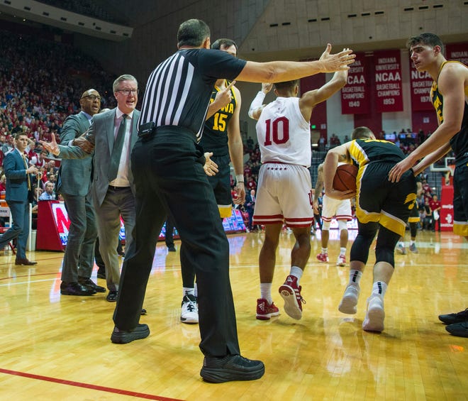 An assistant coach attempts to restrain Iowa head coach Fran McCaffery, second from left, who rushes onto the court toward an official in reaction to a play during the second half of an NCAA college basketball game against Indiana, Thursday, Feb. 13, 2020, in Bloomington, Ind. A technical foul was called against Iowa's bench. (AP Photo/Doug McSchooler)