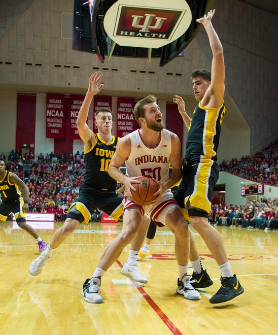 Indiana forward Joey Brunk (50) is stopped by the defense of Iowa guard Joe Wieskamp (10), left, and center Luka Garza (55) during the first half of an NCAA college basketball game, Thursday, Feb. 13, 2020, in Bloomington, Ind. (AP Photo/Doug McSchooler)