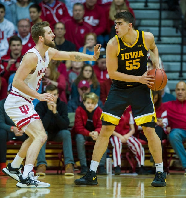 Iowa center Luka Garza (55) is defended by Indiana forward Joey Brunk (50) during the first half of an NCAA college basketball game, Thursday, Feb. 13, 2020, in Bloomington, Ind. (AP Photo/Doug McSchooler)
