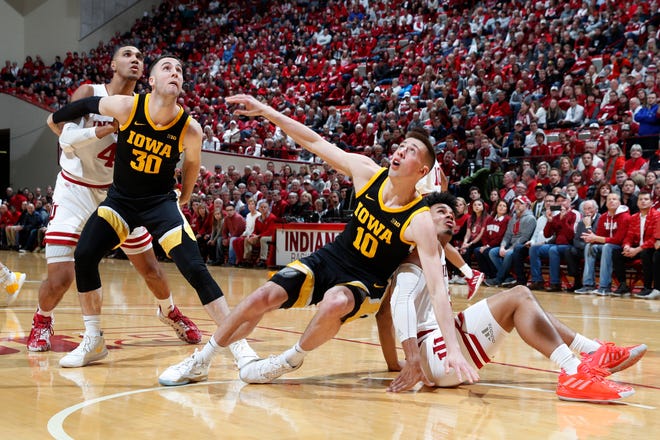 Feb. 13, 2020; Bloomington, Indiana, USA; Indiana Hoosiers forward Justin Smith (3) and Iowa Hawkeyes guard Joe Wieskamp (10) slip on the floor while battling for rebounding position during the first half at Simon Skjodt Assembly Hall.