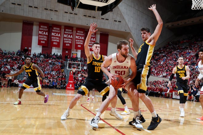 Feb. 13, 2020; Bloomington, Indiana, USA; Indiana Hoosiers forward Joey Brunk (50) is guarded by Iowa Hawkeyes center Luka Garza (55) and guard Joe Wieskamp (10)  during the first half at Simon Skjodt Assembly Hall.