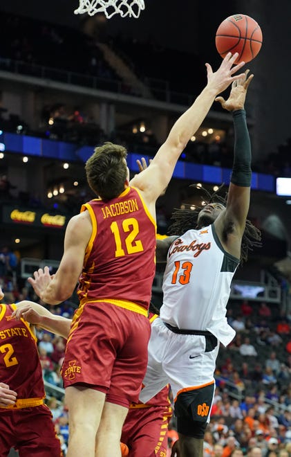 Isaac Likekele (13) of the Oklahoma State Cowboys lays the ball up against Michael Jacobson (12) of the Iowa State Cyclones in the first half during the first round of the Big 12 Basketball Tournament at Sprint Center on March 11, 2020, in Kansas City, Missouri.