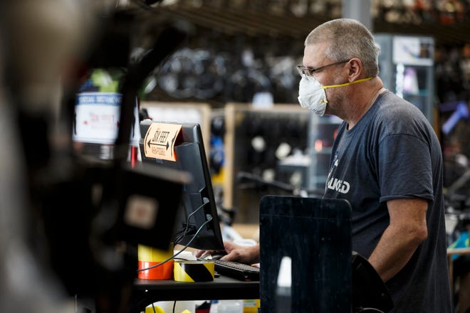 Bike World employee Andy Stewart, 60 of Des Moines, checks a customer order on Friday, May 15, 2020 in West Des Moines.