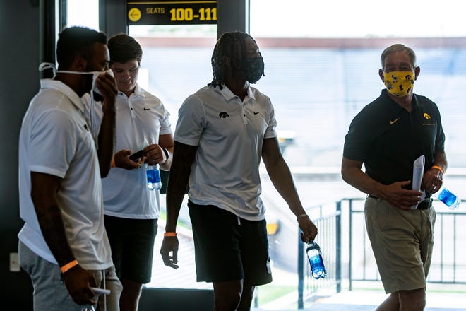 Iowa head coach Kirk Ferentz, right, talks with players, from left, Djimon Colbert, Tyler Linderbaum, and Brandon Smith after a news conference, Thursday, July 16, 2020, at the Pacha Family Club Room in the north end zone of Kinnick Stadium in Iowa City, Iowa.