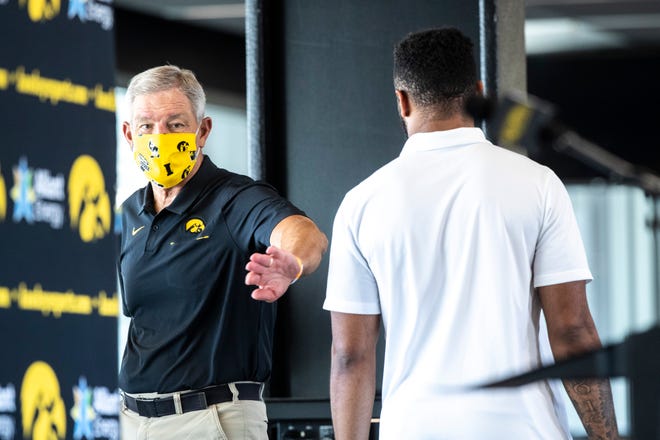 Iowa head coach Kirk Ferentz, left, pats linebacker Djimon Colbert on the shoulder after speaking during a news conference, Thursday, July 16, 2020, at the Pacha Family Club Room in the north end zone of Kinnick Stadium in Iowa City, Iowa.