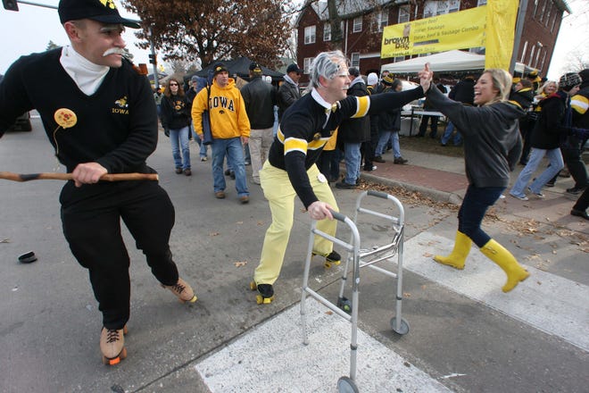 Iowa fans dressed as "seniors" skate by on Melrose Ave. Saturday morning before the Iowa / Ohio State football game.